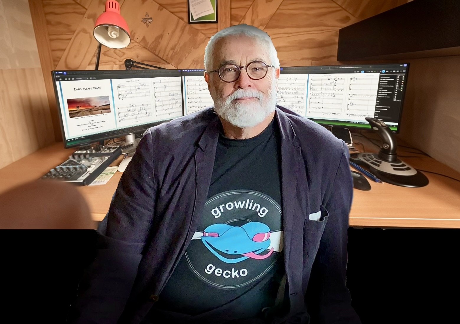 Robin Thomson in his studio with a musical score open across the computer displays